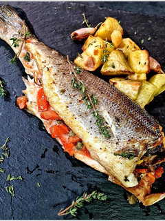Una foto de Lubina rellena acompañada con patatas asadas al tomillo