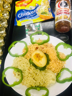 A picture of Chicken schezwan Maggi noodles and tossed boiled egg with Maggi seasoning.