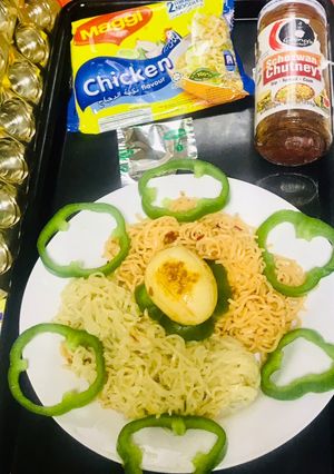 A picture of Chicken schezwan Maggi noodles and tossed boiled egg with Maggi seasoning.