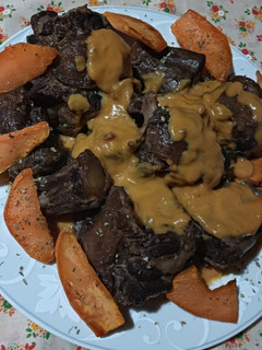 Una foto de Rabo de añojo acompañado de boniato frito