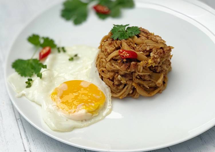 Thai style egg noodles stir-fry served with fried egg