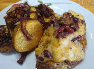 Una foto de Pollo coronado con palmitos, frijoles, choclo y papas encebolladas