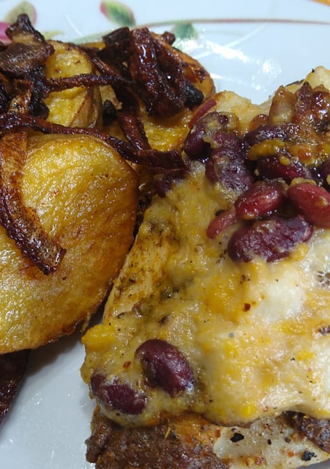 Una foto de Pollo coronado con palmitos, frijoles, choclo y papas encebolladas