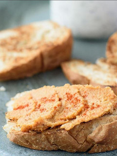 Una foto de Tostadas de pan de campo con dip de humus, oliva y pimentón