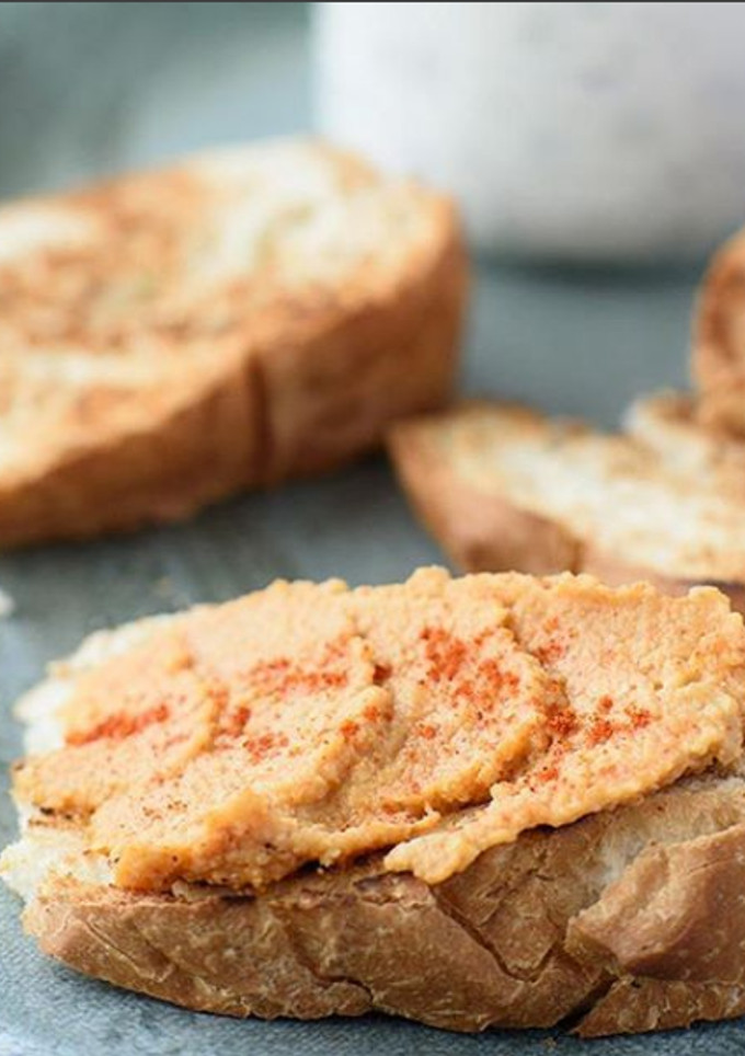 Una foto de Tostadas de pan de campo con dip de humus, oliva y pimentón