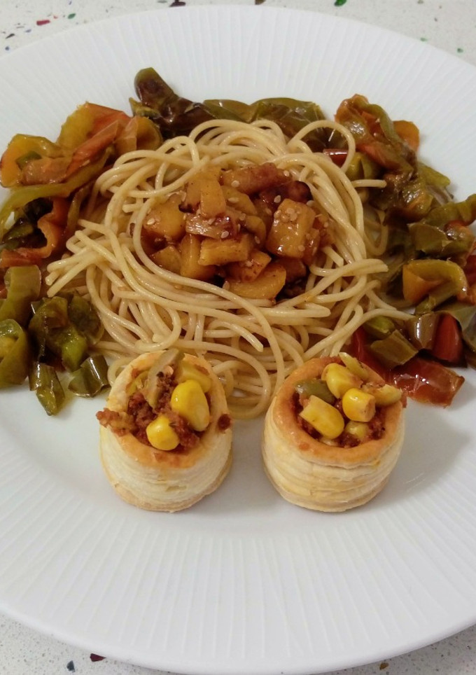 Una foto de Espaguetis salteados con mango y mini volavents rellenos de paté de tomate, aceitunas y maíz