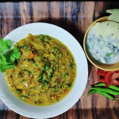 A picture of Shahi Paneer Daliya Khichdi with Cucumber Raita.