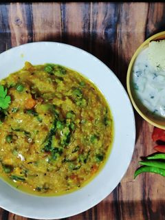 A picture of Shahi Paneer Daliya Khichdi with Cucumber Raita.