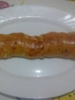 Una foto de Barra rellena de jamón y beicon con masa de pizza con orégano 