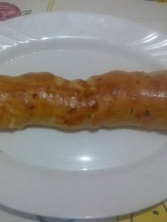 Una foto de Barra rellena de jamón y beicon con masa de pizza con orégano