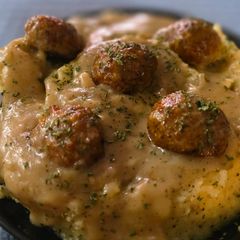 A picture of Mashed potatoes and meatballs.