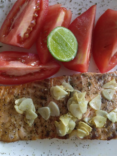 Una foto de Filete de salmón sellado en láminas de ajo adobado con hierbas de mi huerta