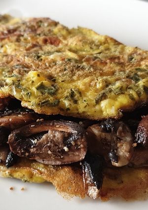 Une photo de Omelette aux fines herbes garnie de champignons frais