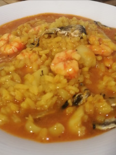 Una foto de Arroz meloso de sepia, cocochas de merluza y gamba roja