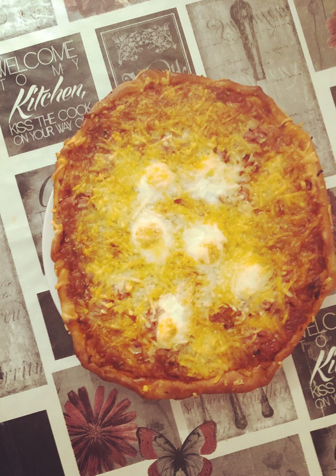 Una foto de Pizza con salsa napolitana bacon, jamón dulce y huevos de codorniz