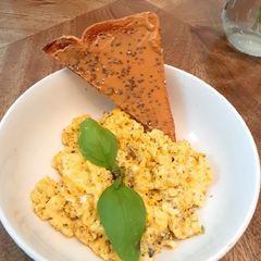 A picture of Scrambled eggs with basil and butter.