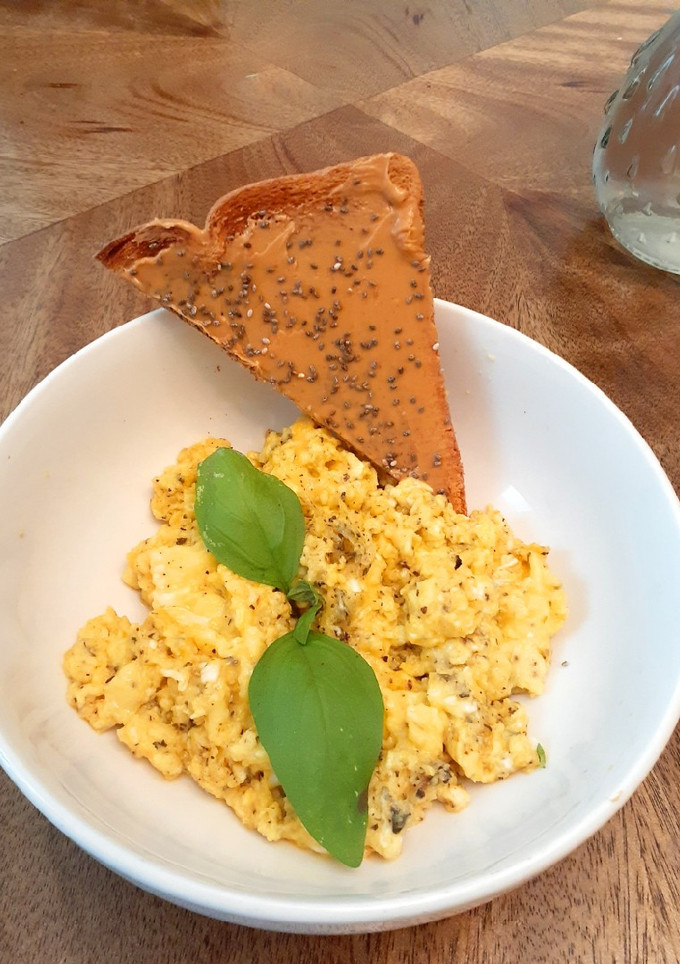 A picture of Scrambled eggs with basil and butter.