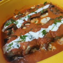 A picture of Brinjal rolls in marinara sauce.