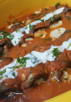 A picture of Brinjal rolls in marinara sauce.