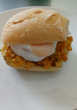 A picture of Veggie fritters and poached egg in a bun.