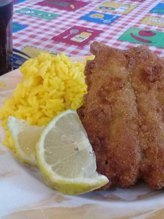 Una foto de Milanesa de bagre y arroz amarillo