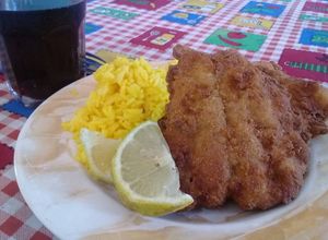 Una foto de Milanesa de bagre y arroz amarillo