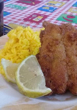 Una foto de Milanesa de bagre y arroz amarillo