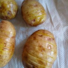 A picture of Potatoes baked in a microwave.