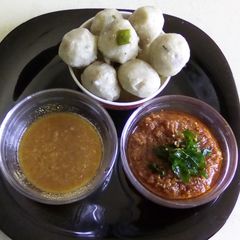 A picture of Steamed rice balls with sizzled spicy chutney.