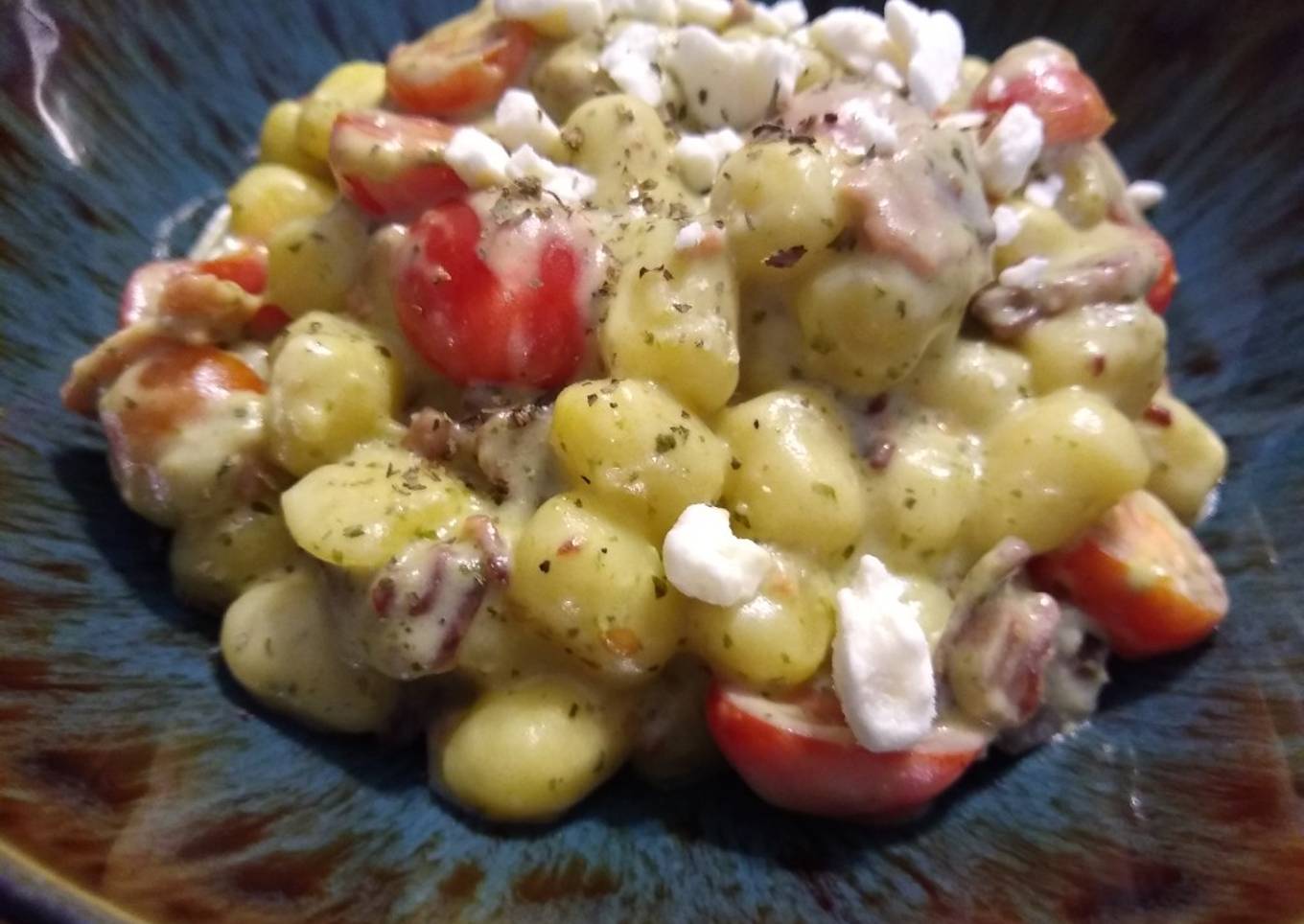 Pesto gnocchi with tomato and bacon