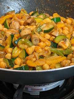 Una foto de Wok de verduras en su jugo con champiñones y garbanzos