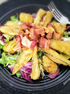Una foto de Ensalada templada de alcachofa y berenjena en tempura con torreznos