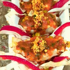A picture of Paneer packets in tomato gravy.