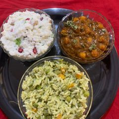 A picture of Satvik platter of Pulao chole masala and curd rice.