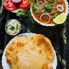 A picture of Punjabi Chole Bhature with Pineapple Raita.