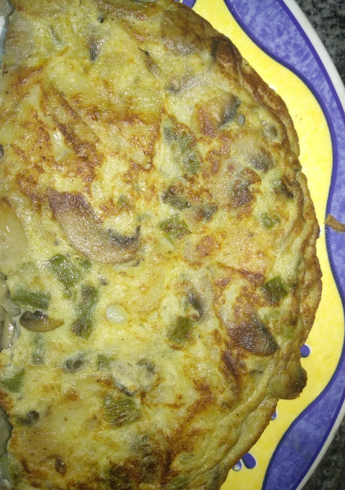 Una foto de Tortilla de patatas con cebolla, espárragos verdes y champiñones