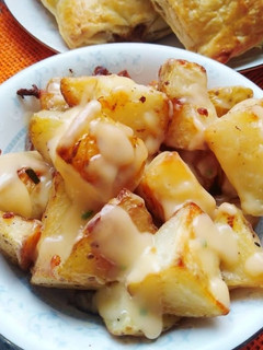 A picture of Roasted potatoes with mushroom sauce.