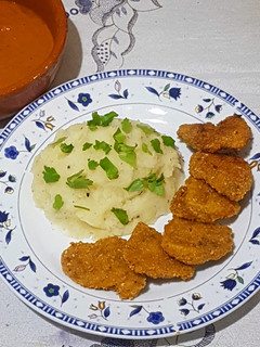 Una foto de Nuggets de pollo con puré de papas y salsa picante
