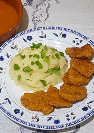 Una foto de Nuggets de pollo con puré de papas y salsa picante