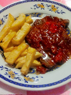 Una foto de Bistec en salsa de tomate con papas fritas