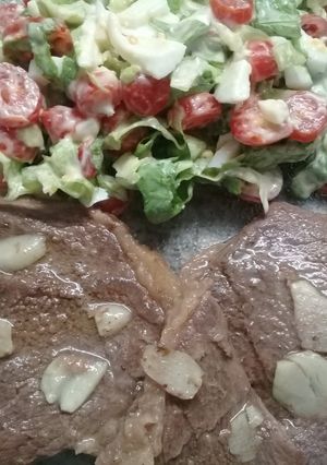 Una foto de Bifes al ajillo con ensalada mixta