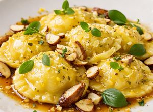 Foto de Ravioli de Mandioquinha e Burrata ao Molho de Manteiga de Sálvia com Crocante de Castanha-do-Pará e