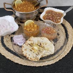 A picture of Chur Chur Naan Thali Chole Imli pyaaz chutney laccha pyaaz Chur chur Naan (Punjabi Dinner Thali).