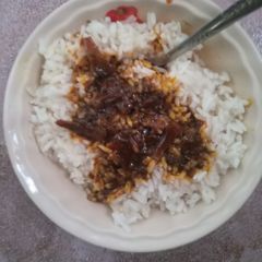 A picture of White Rice and Okpehie(locust beans) Sauce.