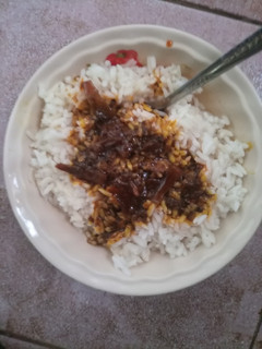 A picture of White Rice and Okpehie(locust beans) Sauce.