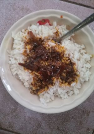 A picture of White Rice and Okpehie(locust beans) Sauce.