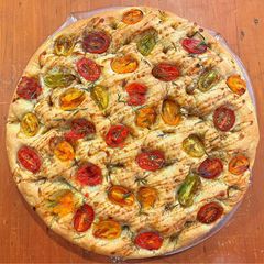 A picture of Foccacia with cherry tomatoes, rosemary and pomegranate molasses.