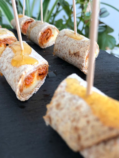 Una foto de Aperitivo de sobrasada, queso y miel en flautas de tortillas de maíz