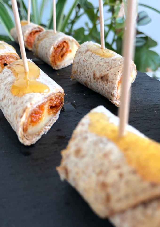 Una foto de Aperitivo de sobrasada, queso y miel en flautas de tortillas de maíz