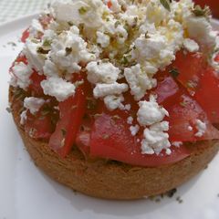 A picture of Traditional Cretan Barley Dakos with Feta Cheese and Tomatoes.